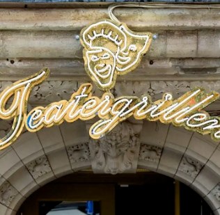 Teatergrillens skylt i guldneon över entrén